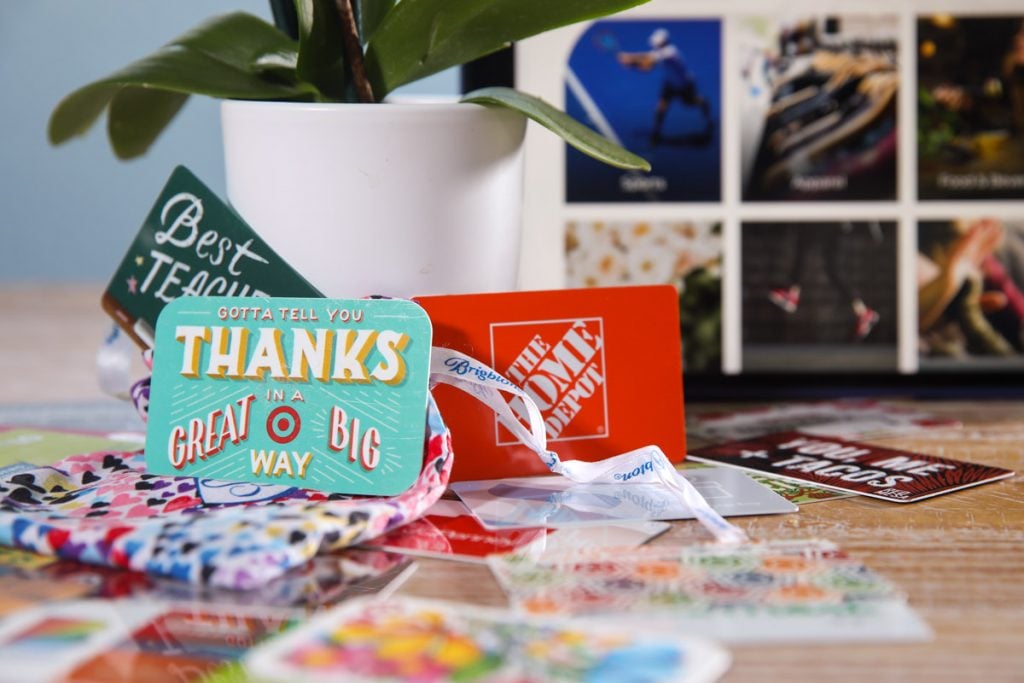 Les cartes-cadeaux sont assises sur une table et ont également calé une plante.