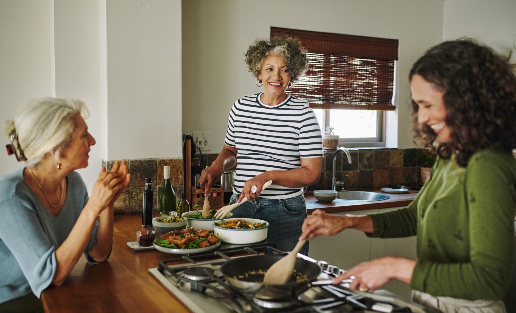 Des femmes matures riant en cuisinant ensemble dans la cuisine 