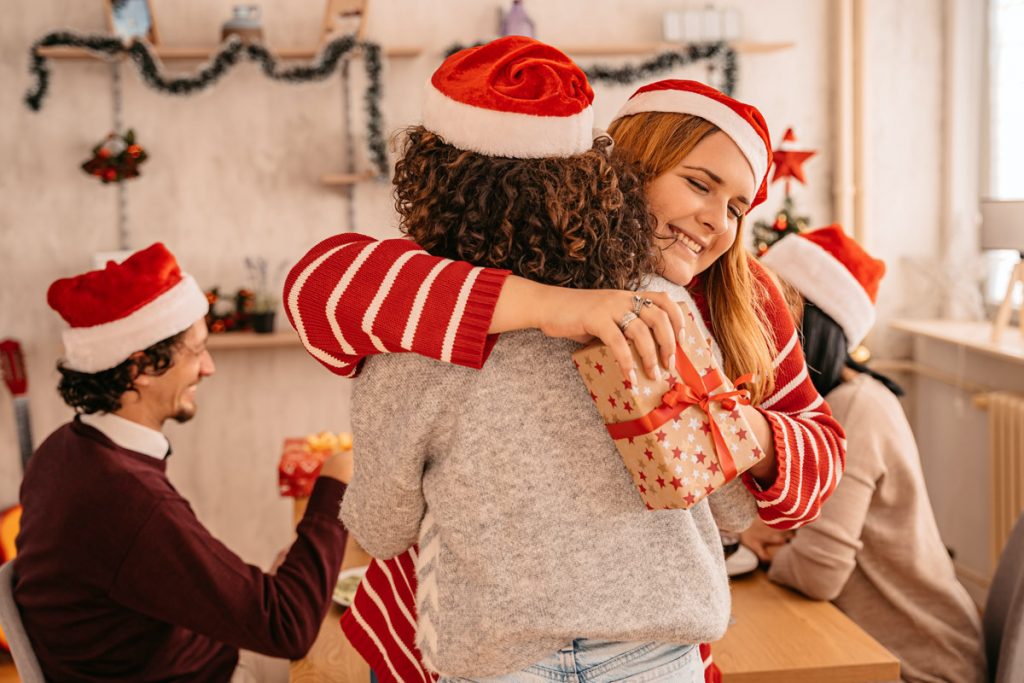 Les amis s'embrassent pendant qu'ils échangent des cadeaux.
