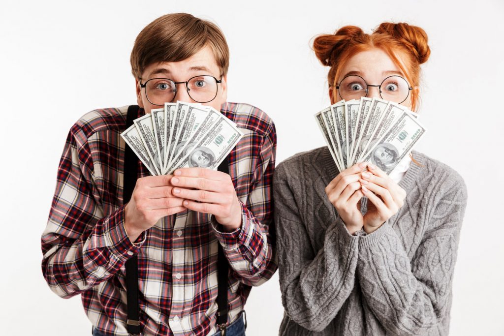 Un couple flash de l'argent devant leur visage sur cette photo.