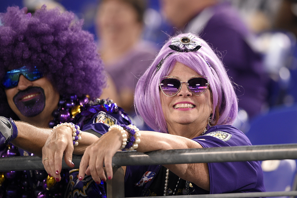 L'homme et la femme portant des perruques violettes dans les tribunes alors qu'ils regardent un match de football de la NFL entre les Ravens et les Buffalo Bills