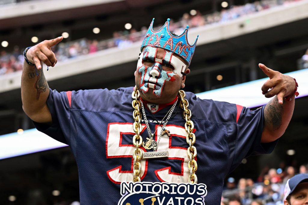 Un homme dans un maillot de Houston Texans assiste à un match de football.
