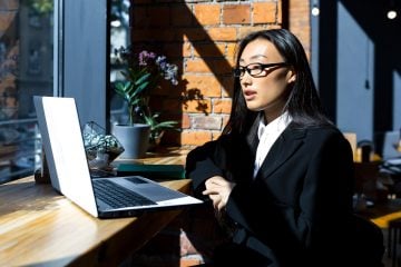 Une femme travaille à distance d'un café.