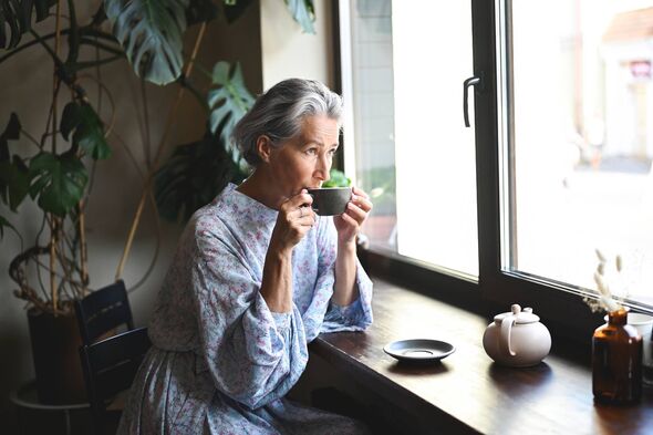Femme candide buvant du thé chaud.