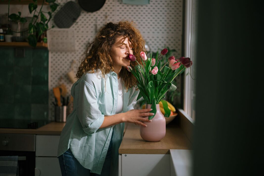 Femme souriante, sentant le bouquet de fleurs