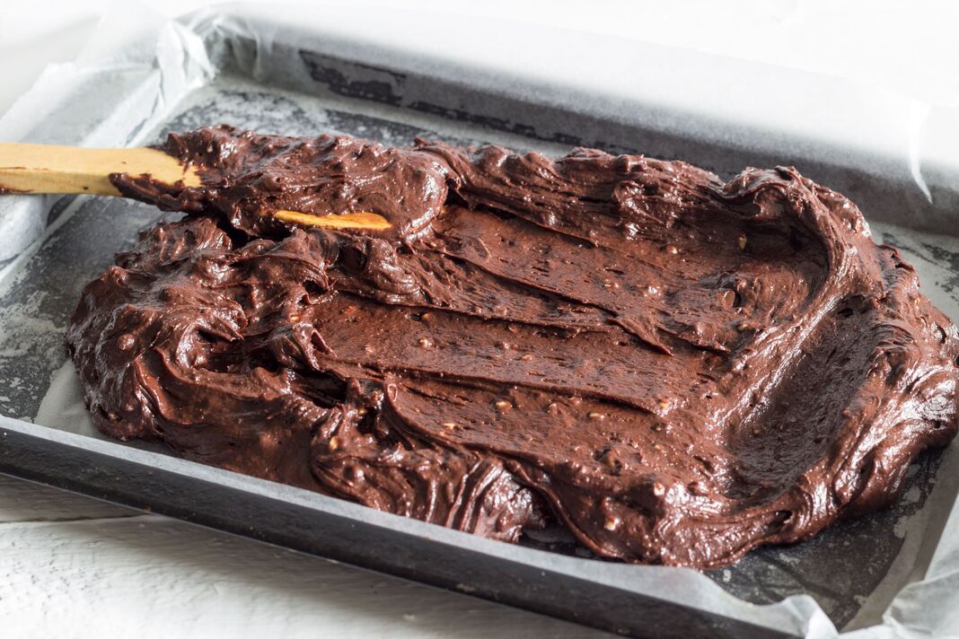 Pâte à gâteau brownie au chocolat placée dans un moule recouvert de papier ciré