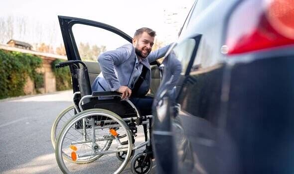 un homme en fauteuil roulant qui monte dans une voiture