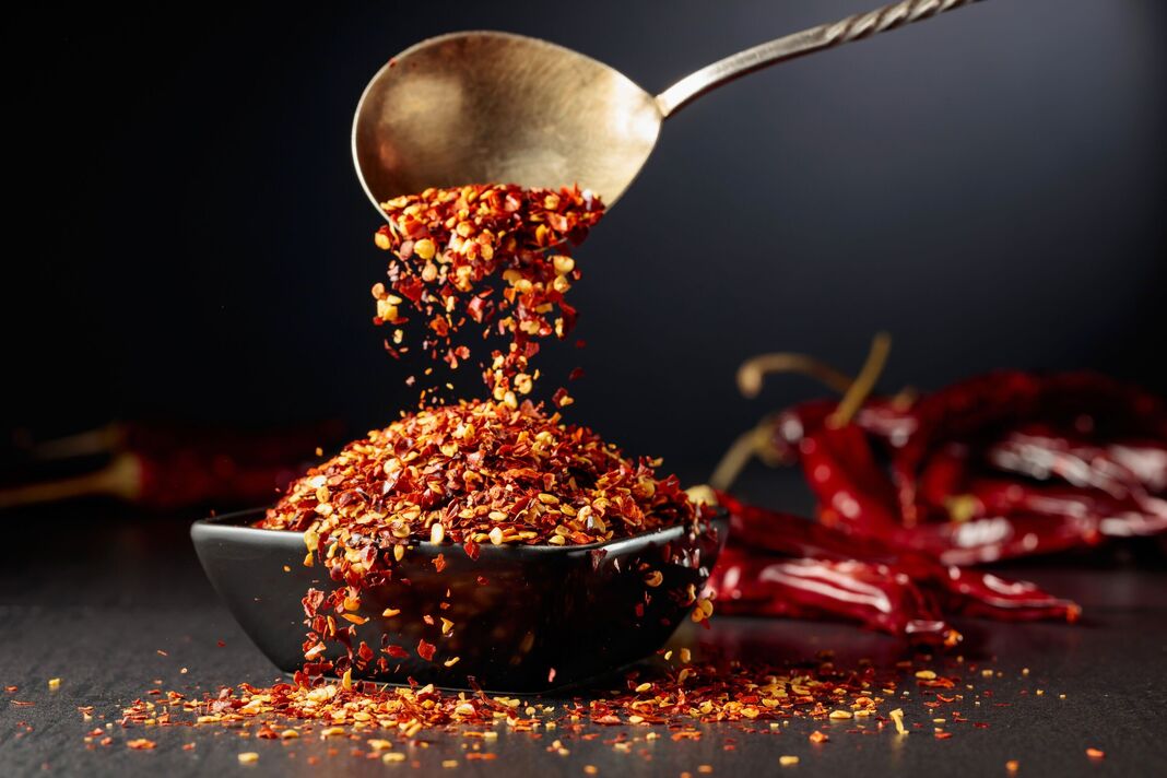 Les flocons de piment sont versés dans un plat noir.