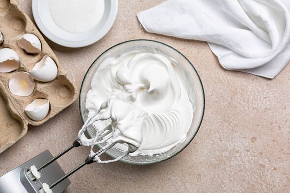 Blancs d'œufs battus avec le sucre pour Meringue dans un bol à mélanger avec un fouet électrique. Processus de cuisson avec des ustensiles de cuisine.