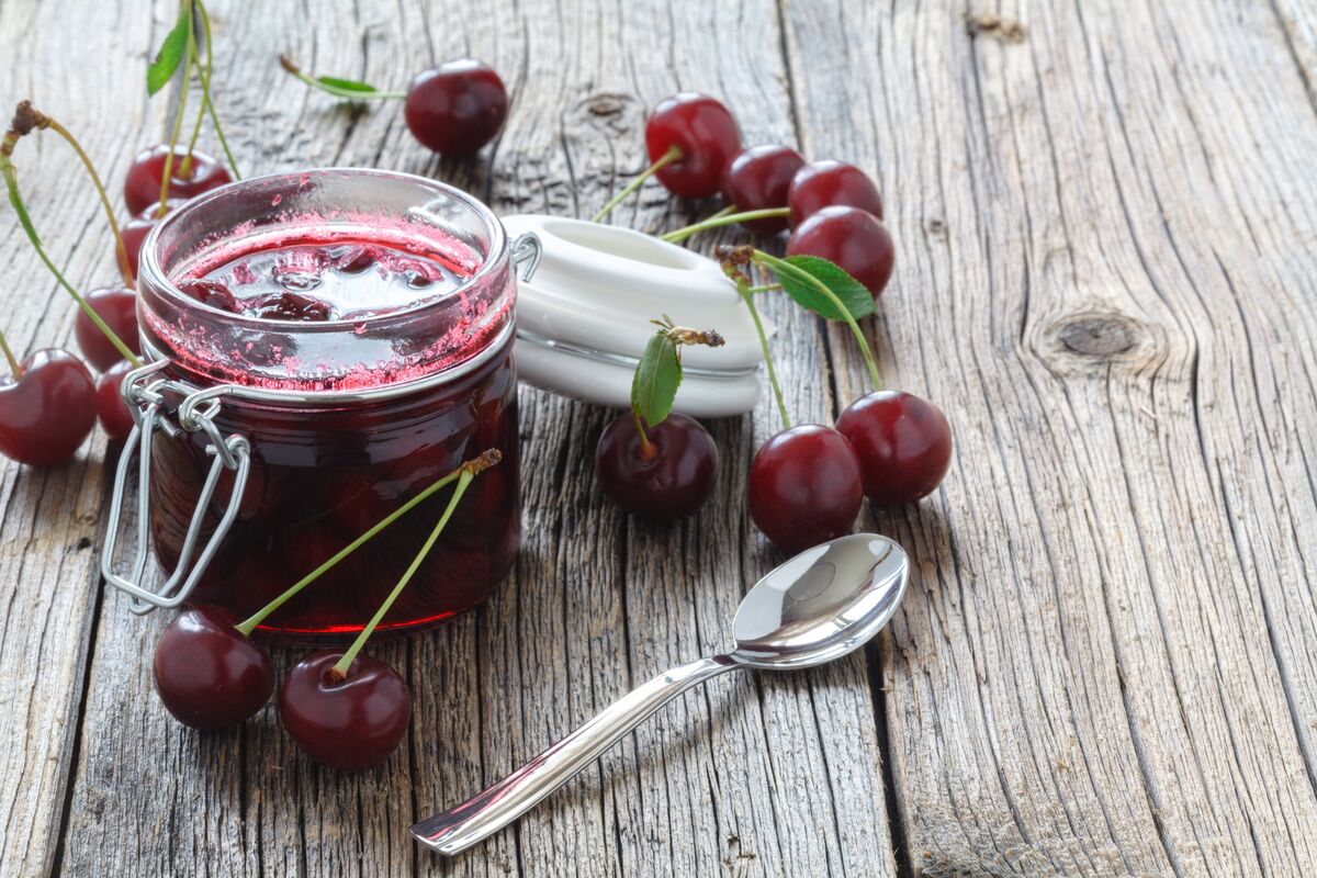 Confiture de cerises / panier de cerises sur fond de bois