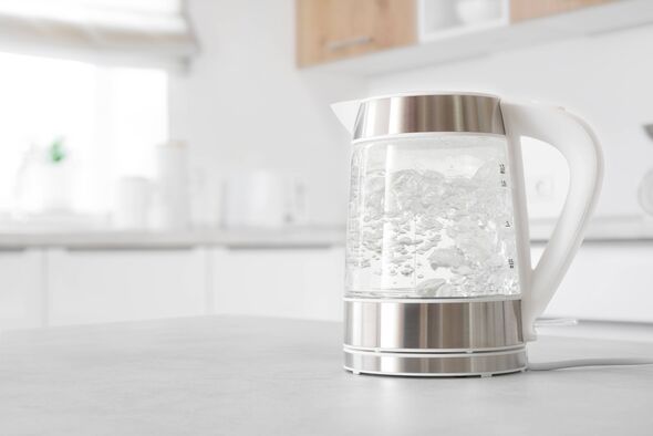 Bouilloire électrique en verre moderne bouillant sur la table de cuisine