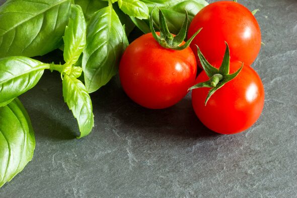 Tomates et basilic sur planche de pierre noire. Tomates et basilic sur planche de pierre noire.