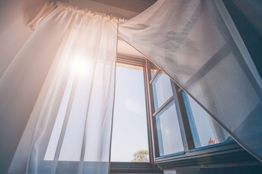 Soleil du matin brillant dans la fenêtre ouverte à travers les rideaux Soleil du matin brillant dans la fenêtre ouverte à travers les rideaux