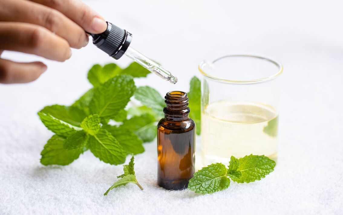 Huile essentielle d'aromathérapie à la menthe poivrée sur fond blanc Huile essentielle d'aromathérapie à la menthe poivrée sur fond blanc
