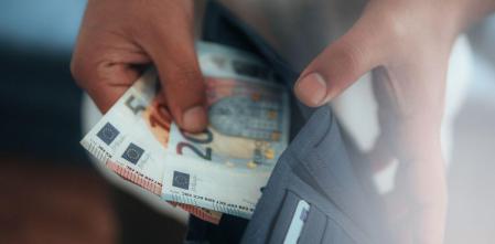 Une personne montre l'argent qu'elle a gagné avec des comptes courants payants