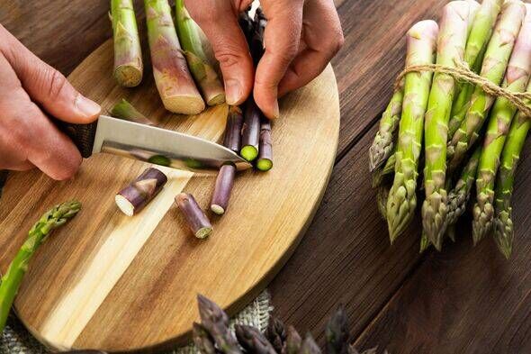 Préparer des asperges fraîches pour cuisiner dans une cuisine rustique Préparer des asperges fraîches pour cuisiner dans une cuisine rustique