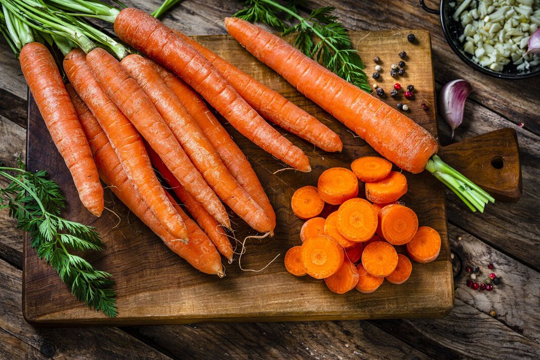 Vue aérienne de carottes biologiques fraîchement tranchées sur une planche à découper Vue aérienne de carottes biologiques fraîchement tranchées sur une planche à découper