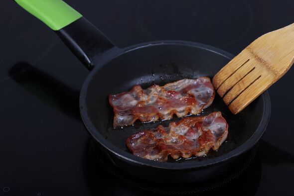 Bacon dans une poêle à frire sur cuisinière à induction Bacon dans une poêle à frire sur cuisinière à induction