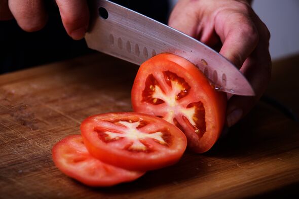 Tomate tranchée avec un couteau de cuisine bien aiguisé Tomate tranchée avec un couteau de cuisine bien aiguisé