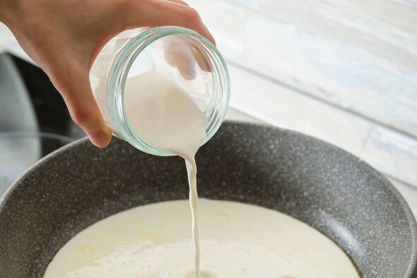 Cuisiner des pâtes italiennes avec une sauce à la crème et au basilic, à la maison. Ajoutez et versez la crème dans l'ail frit et les épices. Végétarien f