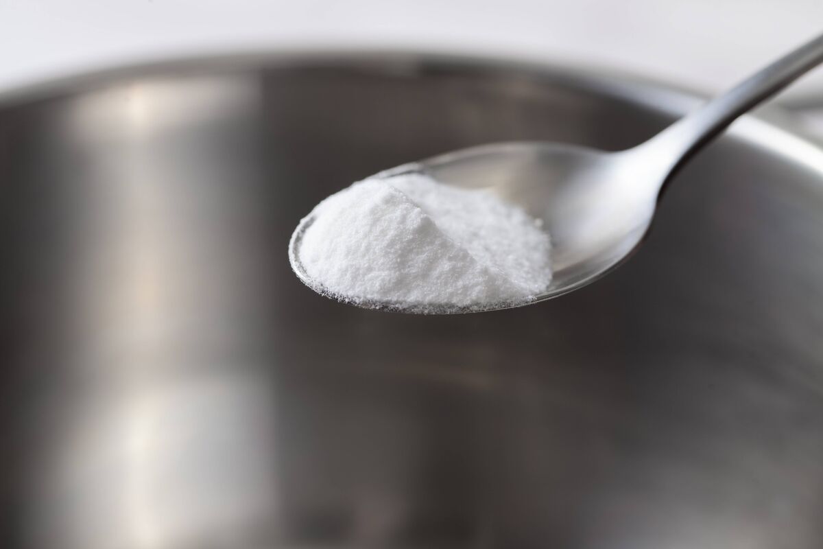 Glissez du bicarbonate de soude dans une cuillère à café en métal sur un plat en métal. Poudre blanche dans une cuillère. Glissez du bicarbonate de soude dans une cuillère à café en métal sur un plat en métal. Poudre blanche dans une cuillère.