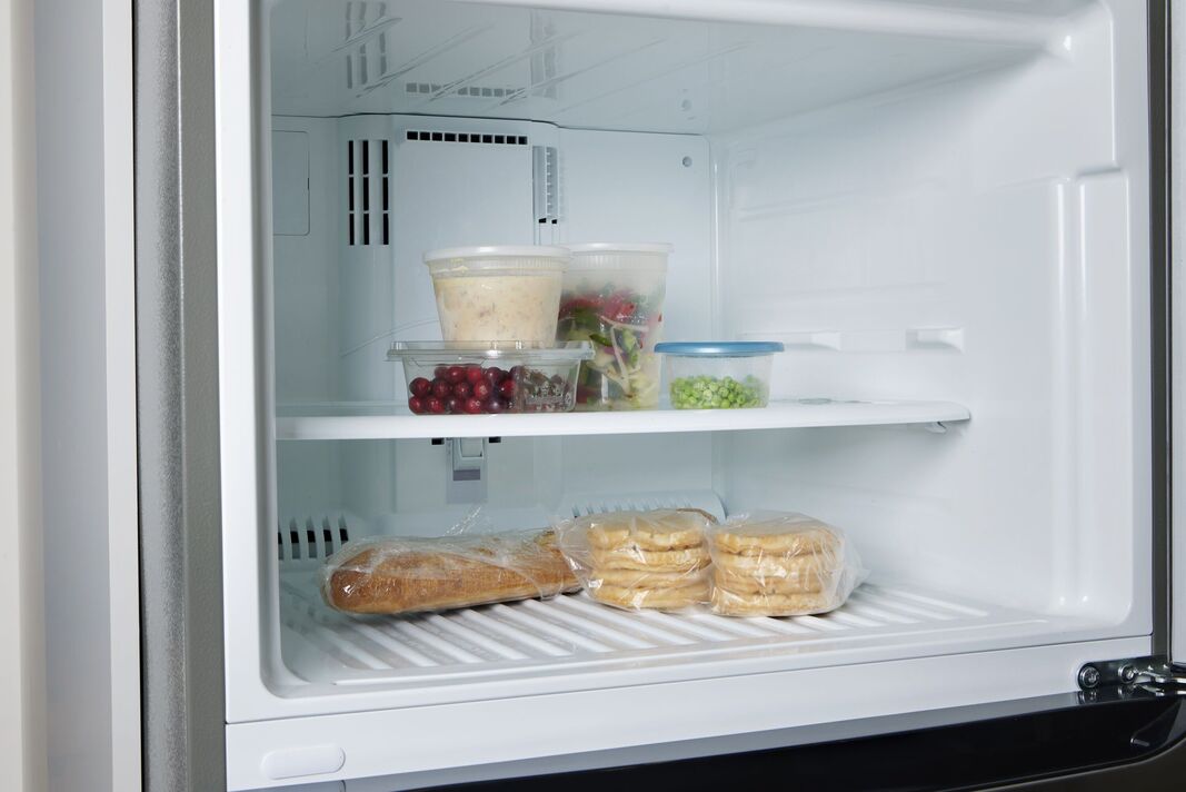 Congélateur presque vide avec restes de nourriture et de pain – Concept alimentaire de récession Congélateur presque vide avec restes de nourriture et de pain – Concept alimentaire de récession