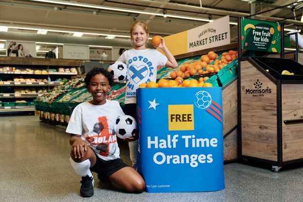 Deux individus sont agenouillés dans un supermarché, posant à côté d'un grand bac bleu étiqueté Deux individus sont agenouillés dans un supermarché, posant à côté d'un grand bac bleu étiqueté