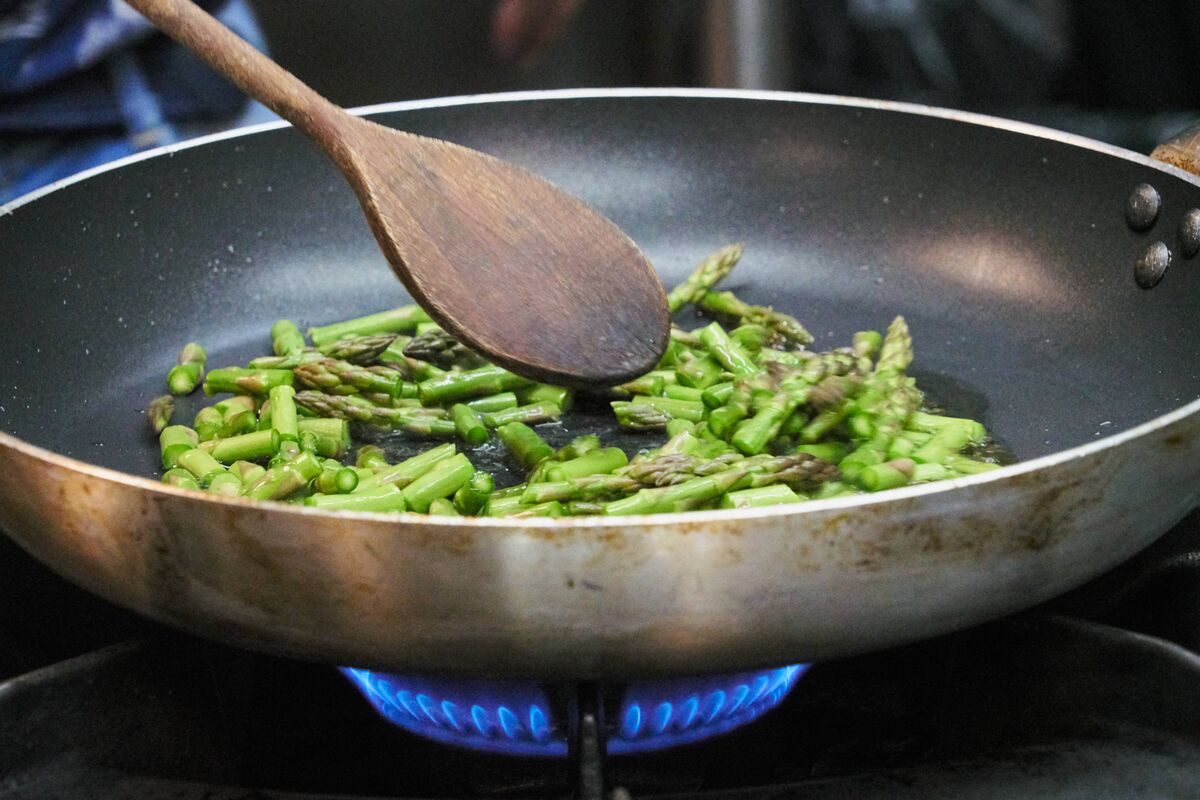 Gros plan d'asperges sautées dans une poêle antiadhésive