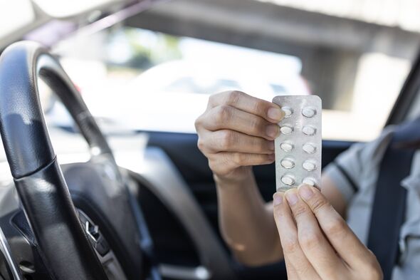 Femme tenant un blister de pilules et prenant des médicaments en conduisant une voiture, dangers de la consommation de certains médicaments pouvant causer des problèmes Femme tenant un blister de pilules et prenant des médicaments en conduisant une voiture, dangers de la consommation de certains médicaments pouvant causer des problèmes