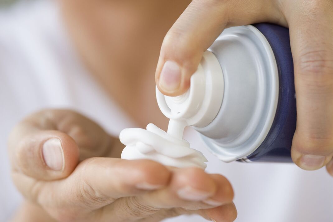 Homme distribuant de la crème à raser dans la main Homme distribuant de la crème à raser dans la main