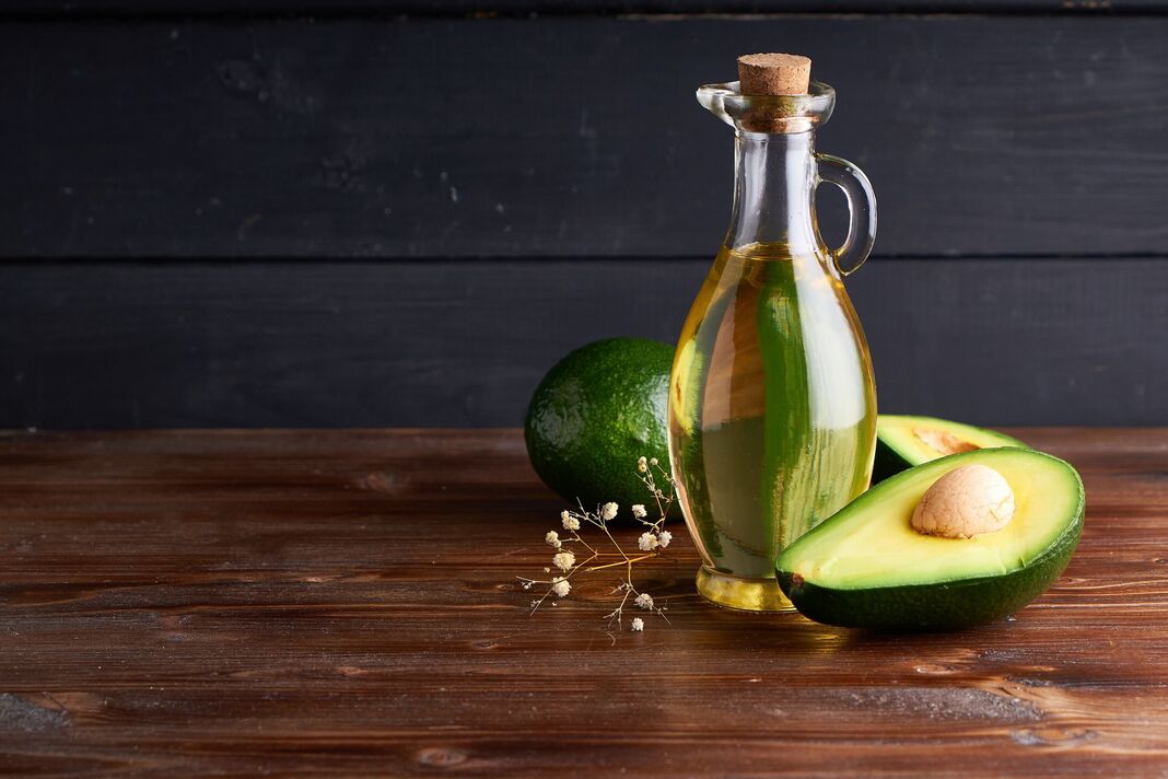 Huile d'avocat saine dans des bouteilles en verre. Espace de copie de fond sombre Huile d'avocat saine dans des bouteilles en verre. Espace de copie de fond sombre